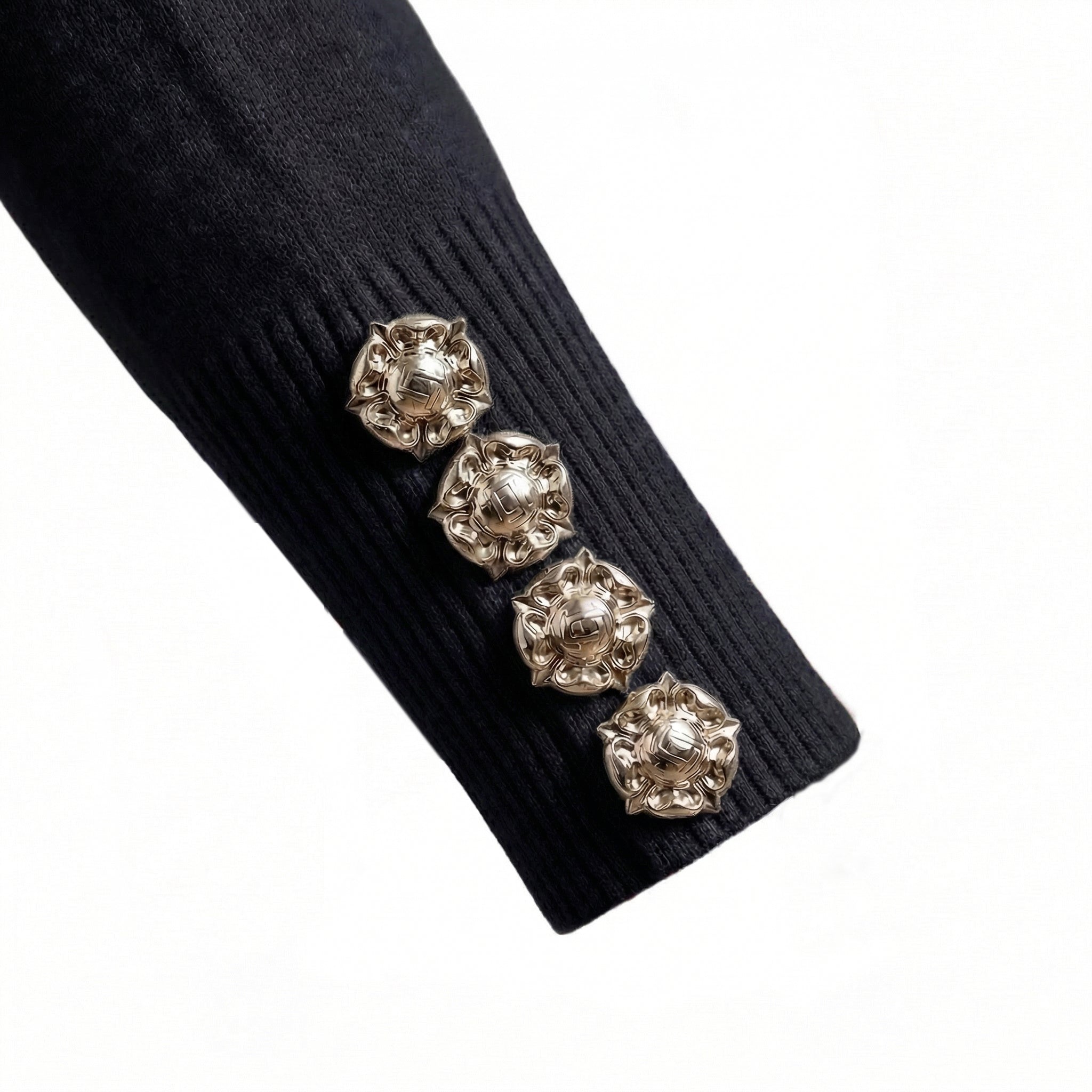 Black ribbed sweater with decorative buttons on a white background