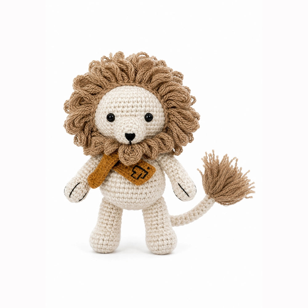 Crocheted lion toy with a scarf on a white background